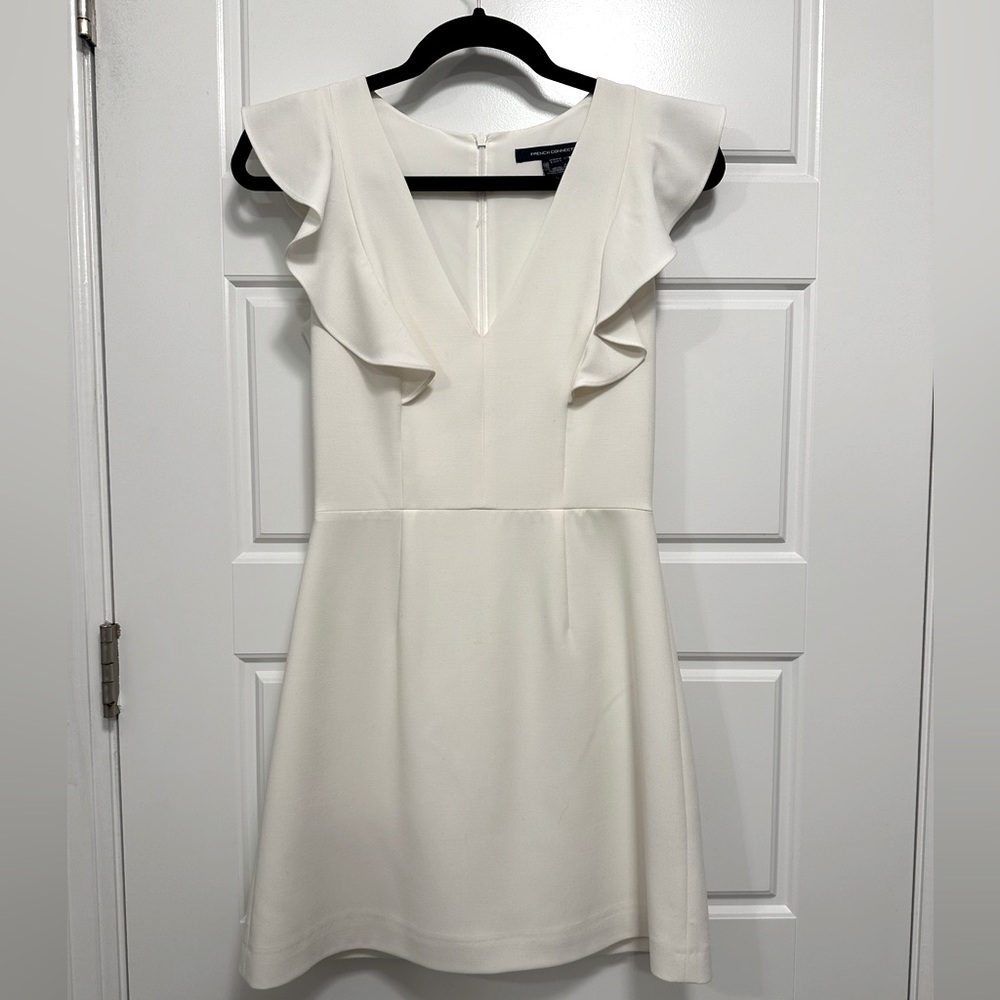 Women’s white mini dress with ruffle sleeves.
